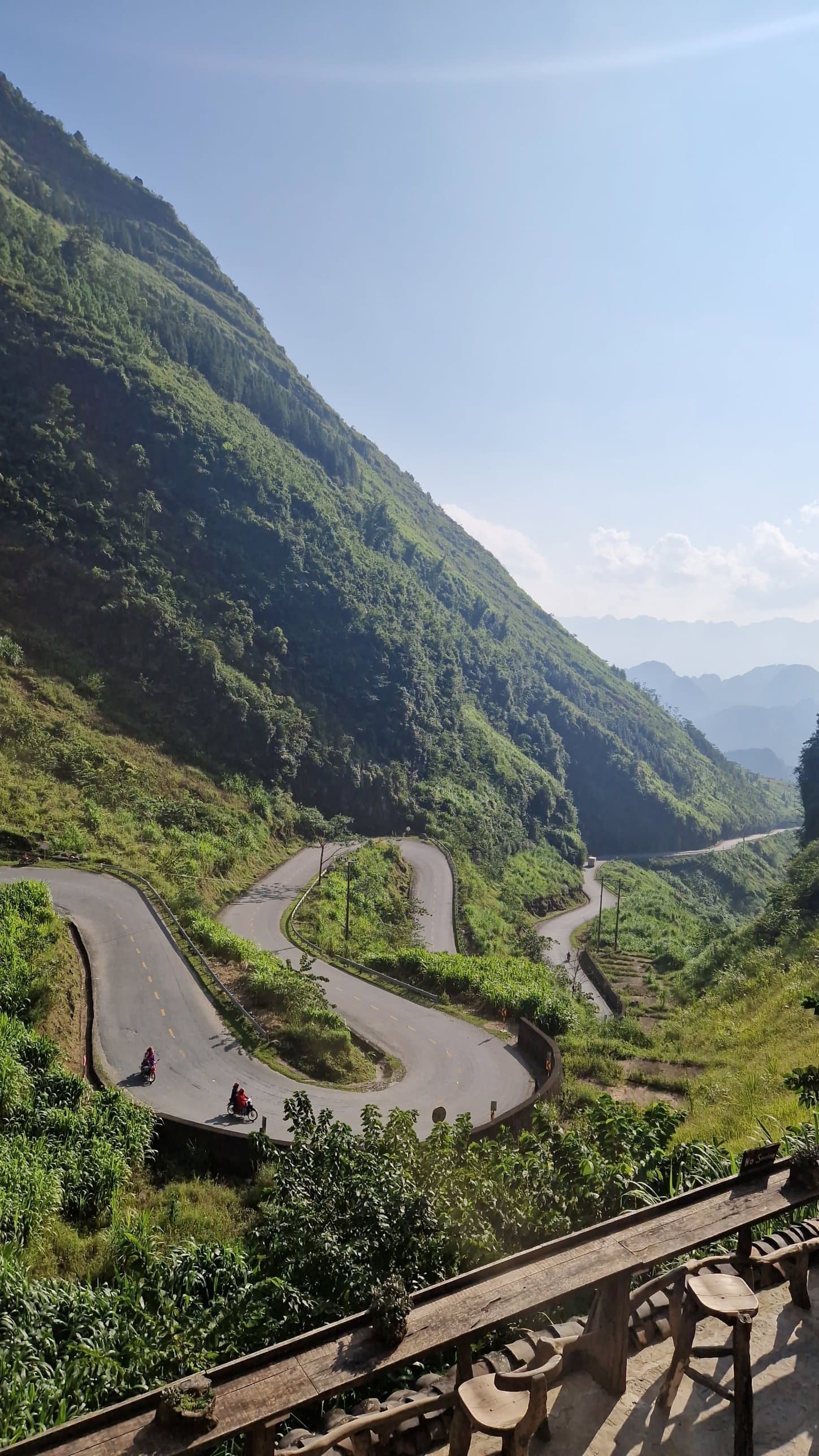 Two motorbike riders on a hairpin bend of a mountain road on the Hà Giang loop
